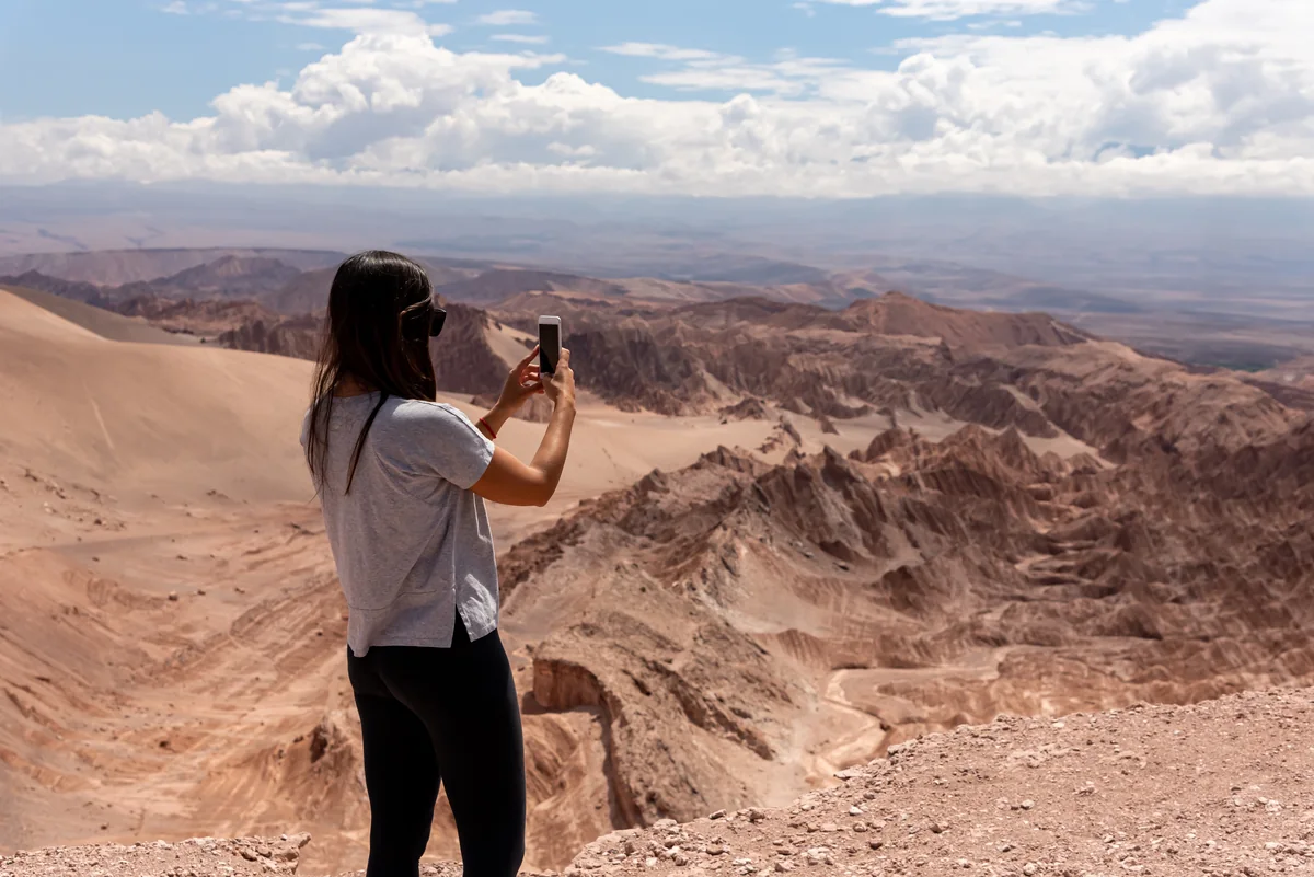 Viajero fotografiando el paisaje del Valle de la Luna al atardecer