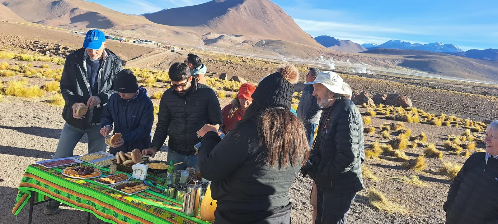 Viajeros compartiendo un desayuno al aire libre junto a un vehículo en Atacama